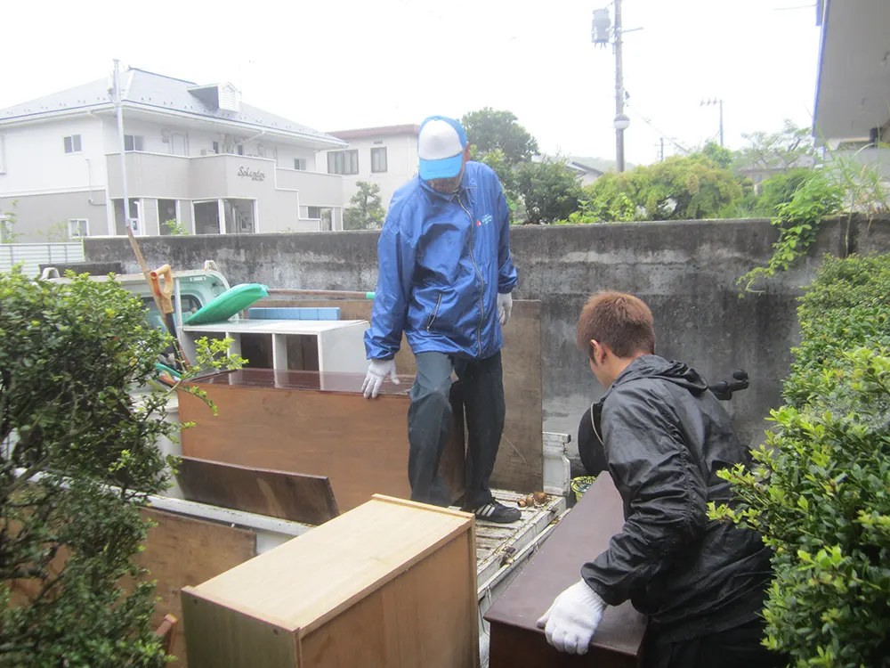 屋外で片付け作業をする作業員