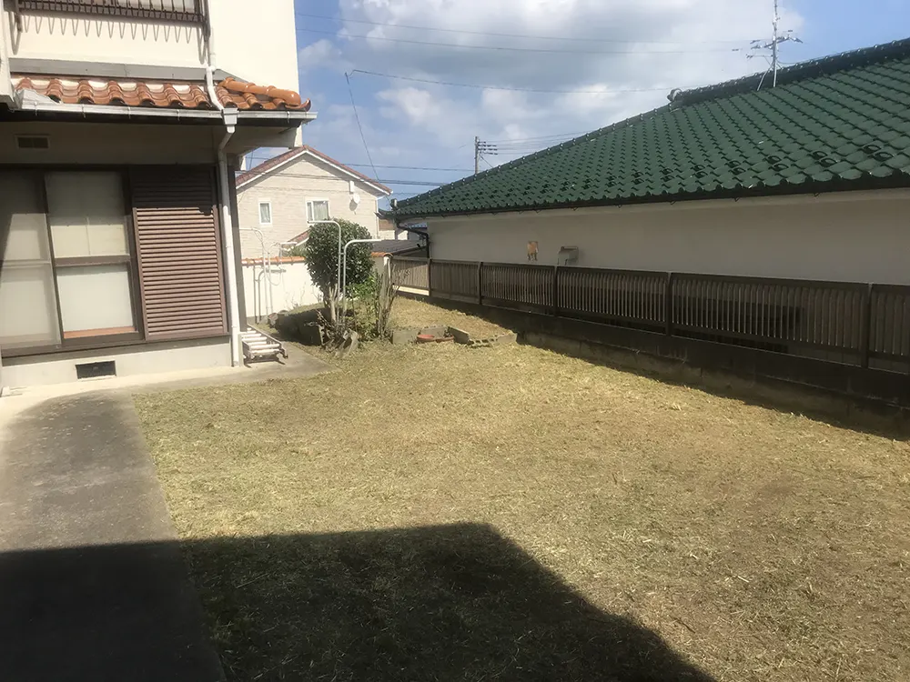 芝生のある庭と住宅（売却の準備を進める住宅と庭のイメージ）