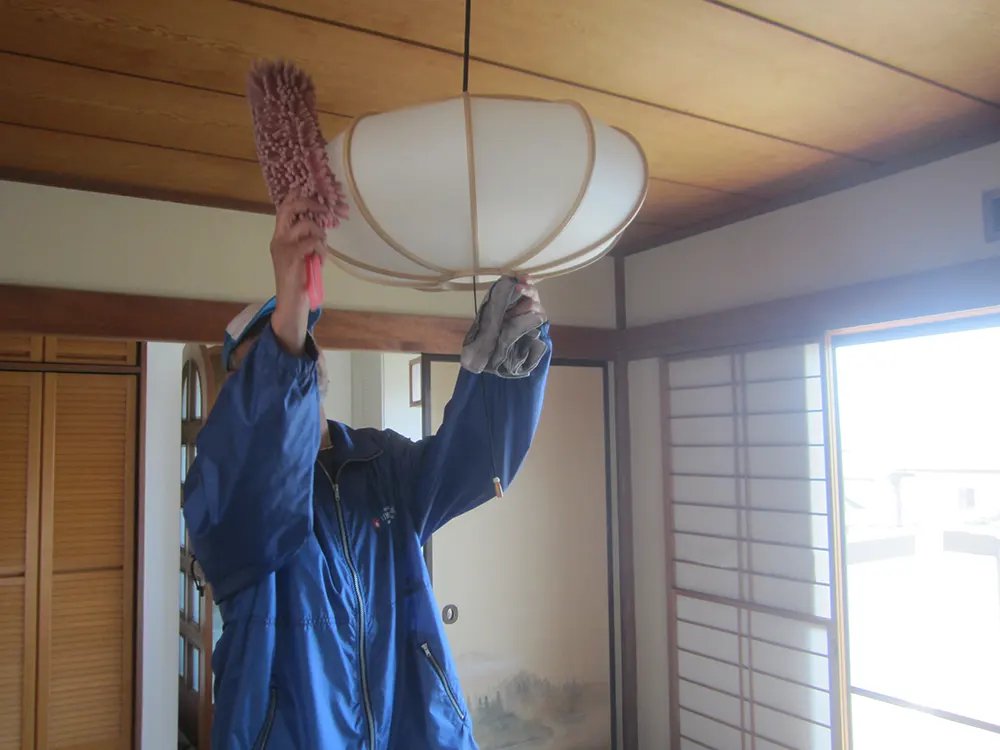 照明を清掃する作業員